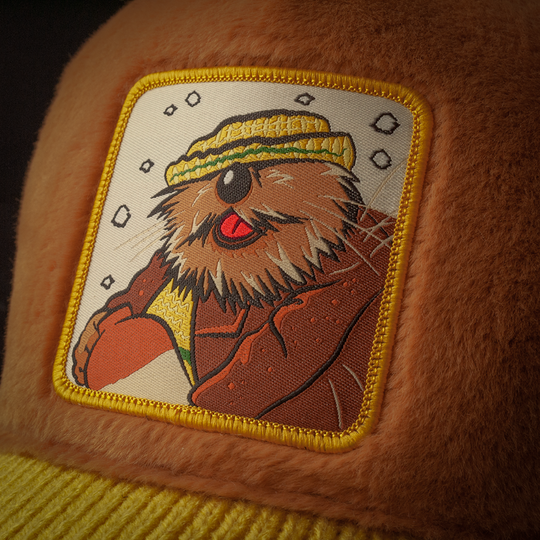 Close-up of a woven patch of Wendell the Porcupine from Emmet Otter attached to the crown.