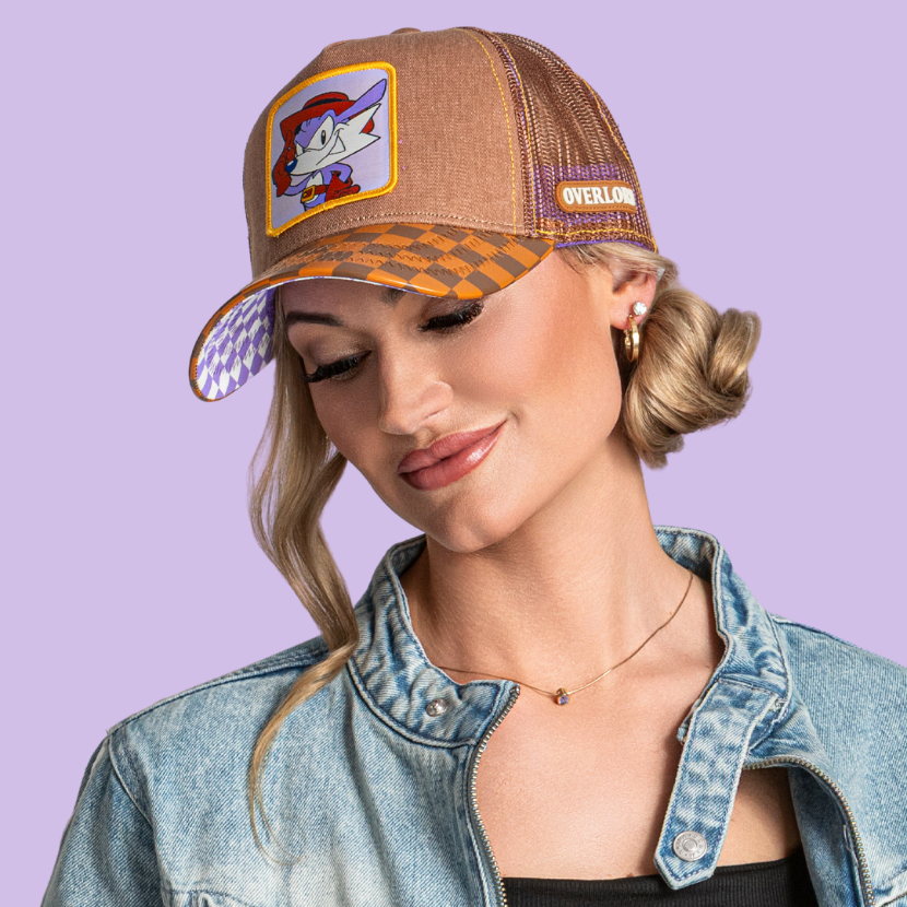 Model wearing the brown Fang from Sonic the Hedgehog retro trucker cap, with checkered brim and purple and brown mesh sides.