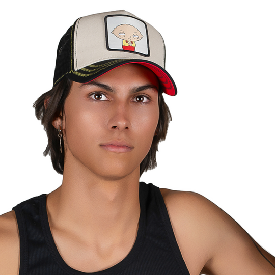 Man wearing black and white twill trucker cap featuring a woven patch of a Stewie Griffin from Family Guy attached to the crown