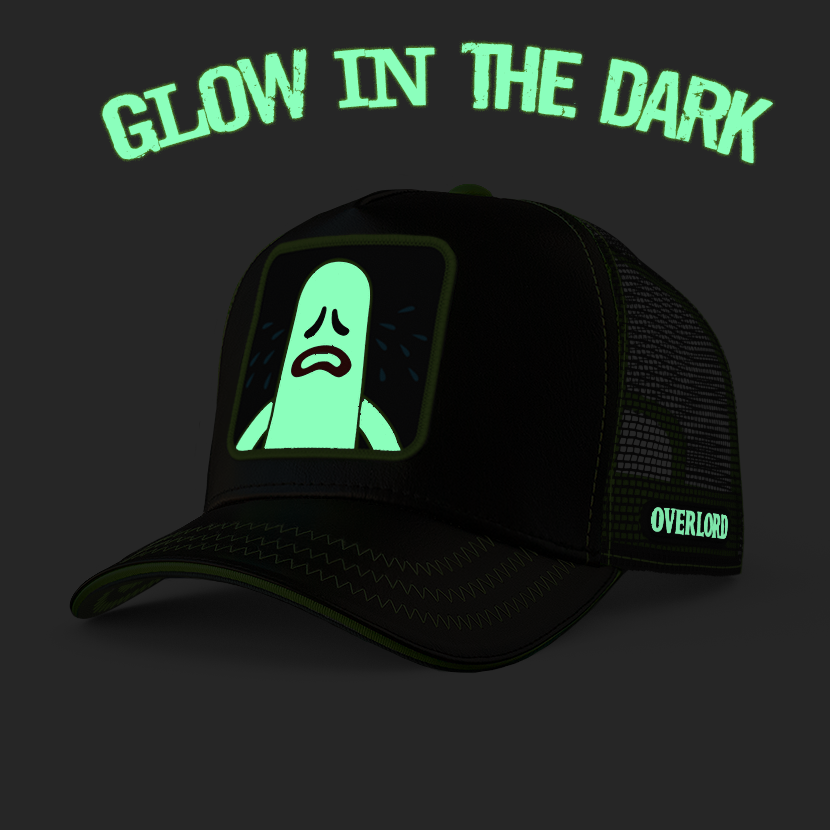 Black cap with a green ghost graphic and 'Glow in the Dark' text on a dark background
