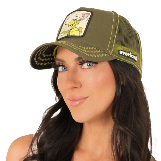 Woman wearing olive green twill trucker cap with olive green mesh featuring a woven patch of Touché Turtle from the classic Hanna-Barbera cartoons attached to the crown.