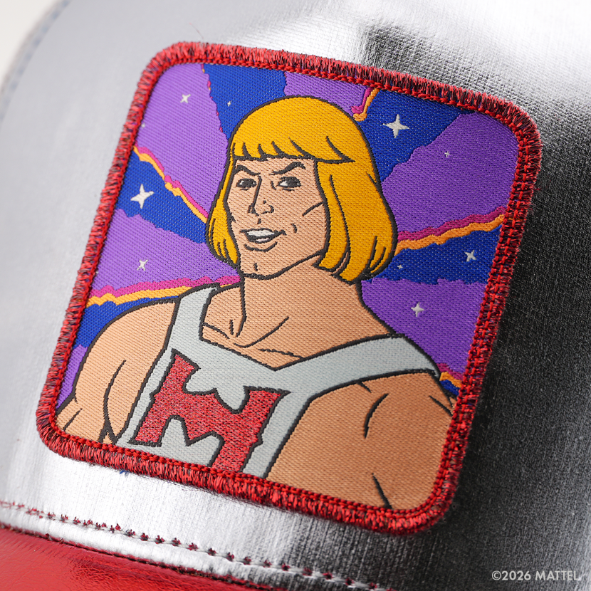 Woven patch of He-Man from Masters of the Universe in a white and red top, set against a starry purple sky background with red border, stitched onto the metallic silver retro trucker cap.