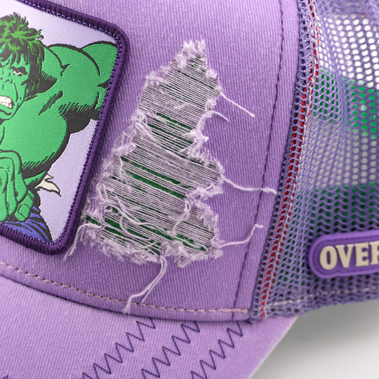 Close-up of a torn fabric detail beside the Hulk patch on the purple cap, with a mesh side panel and Overlord logo.