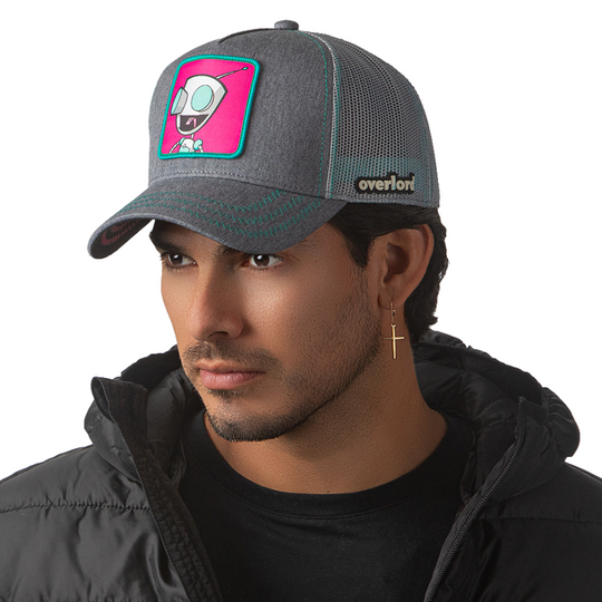 Man wearing heather Gray OVERLORD X Invader Zim GIR robot trucker baseball cap hat with turquoise zig zag stitching. PVC Overlord logo.