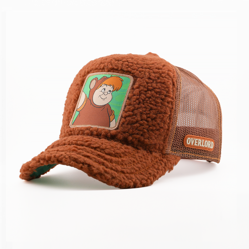 Fuzzy-textured brown retro trucker cap with a patch of Lost Boy Cubby from Disney's Peter Pan on a green background, brown mesh back with tan Overlord logo.