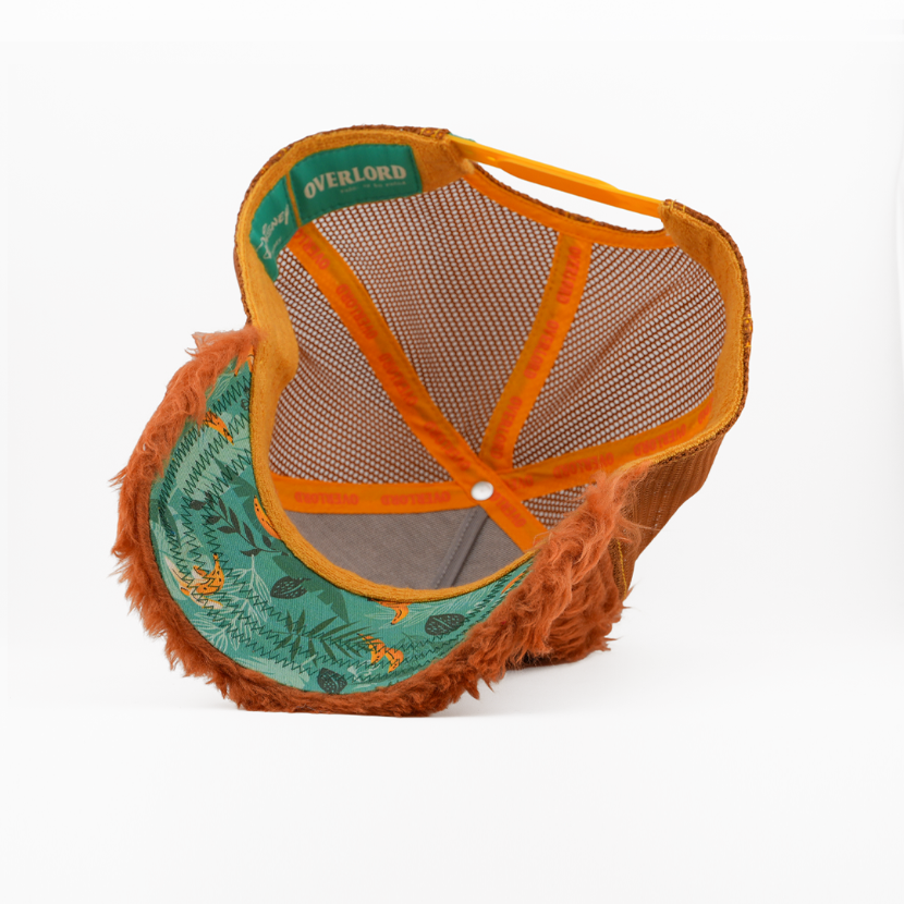 Orange and green cap with fur brim on a white background