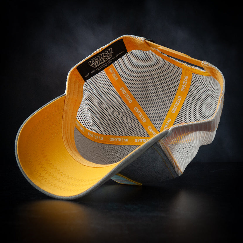 Yellow and gray cap with mesh back on a dark background