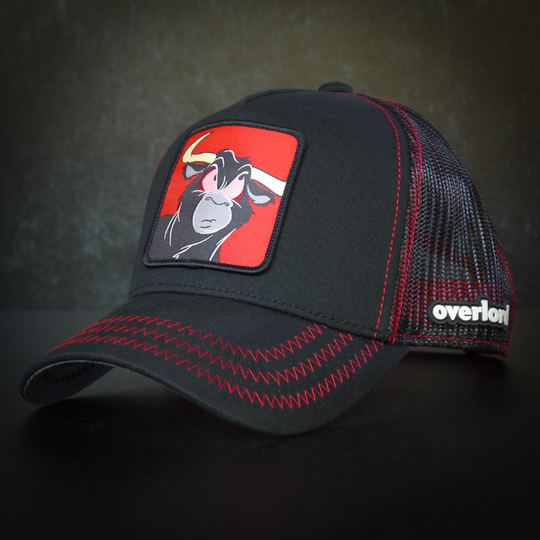 Black OVERLORD X Looney Tunes Toro the bull trucker baseball cap hat with red zig zag stitching. PVC Overlord logo.