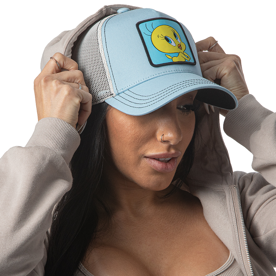 Woman wearing baby blue OVERLORD X Looney Tunes smiling Tweety Bird trucker baseball cap hat with black stitching. PVC Overlord logo.
