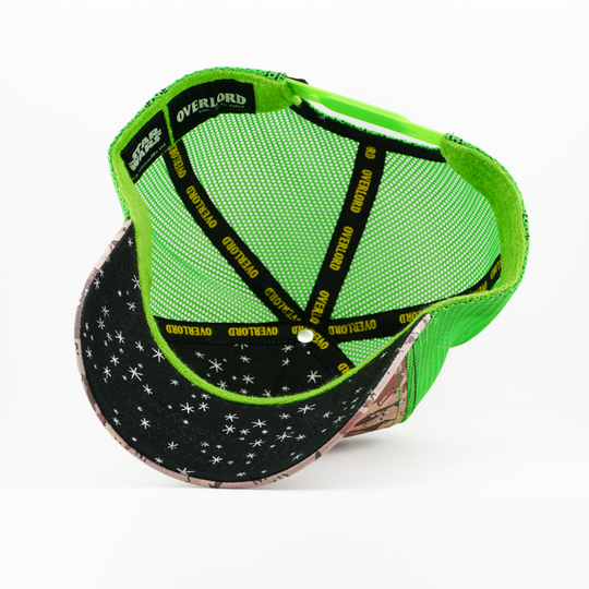 Underside view of the Max Rebo trucker cap showing a starry brim, green mesh crown, and Overlord branded taping.