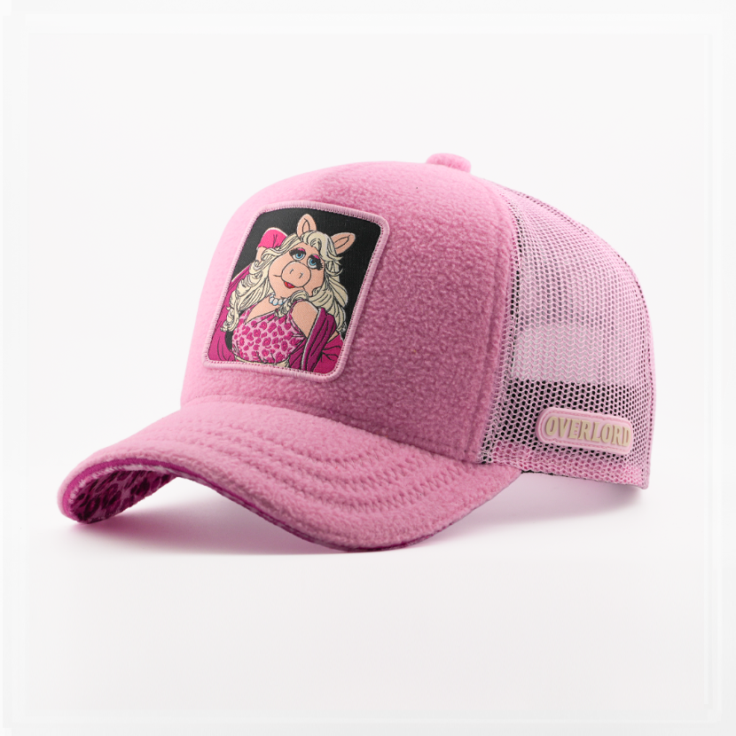 Fuzzy-textured pink retro trucker cap with a leopard-print brim underside and a patch of Miss Piggy from The Muppets on a black background, pink mesh back with tan Overlord logo.