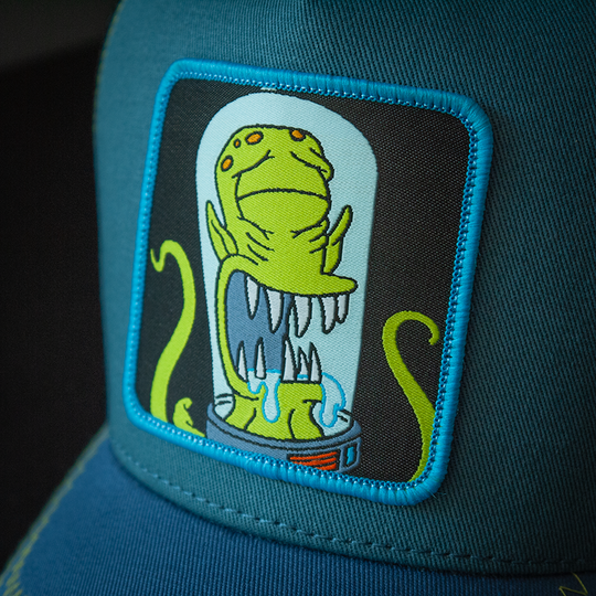 Blue OVERLORD X The Simpsons present Kodos the alien trucker baseball cap hat woven Overlord patch closeup.