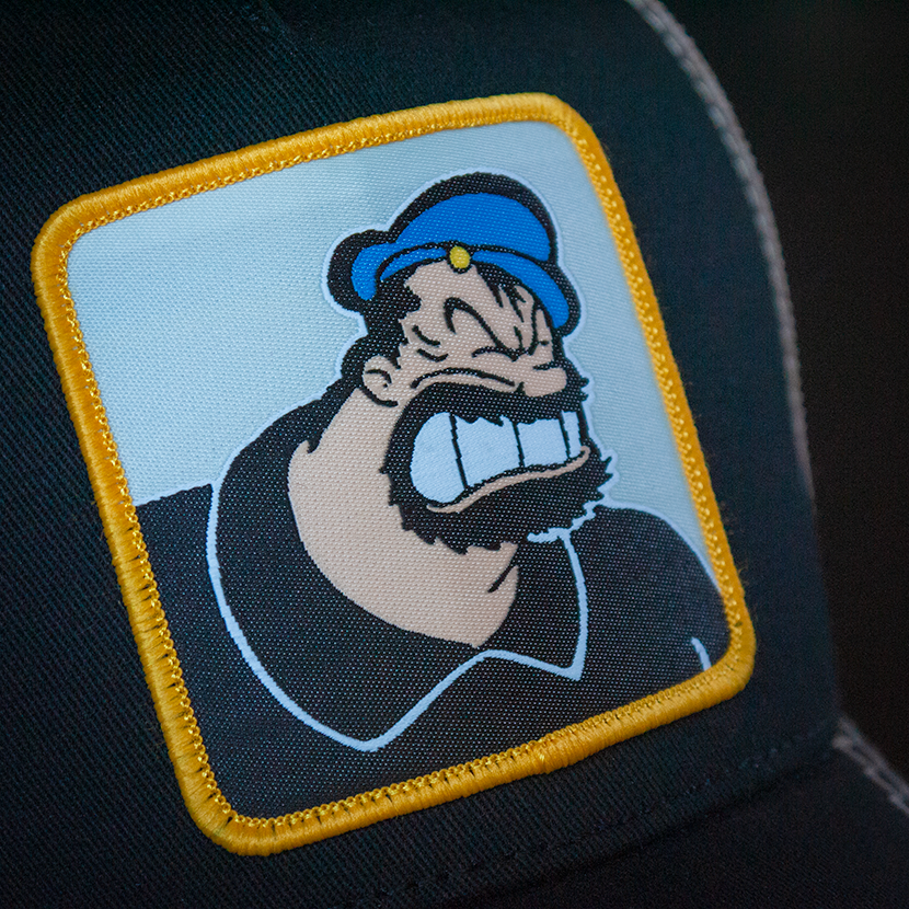 Black OVERLORD X Popeye angry Brutus Bluto trucker baseball cap hat woven Overlord patch closeup.
