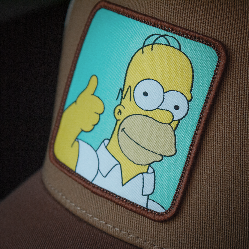 Brown OVERLORD X The Simpsons Homer doing thumbs up trucker baseball cap hat woven Overlord patch closeup.