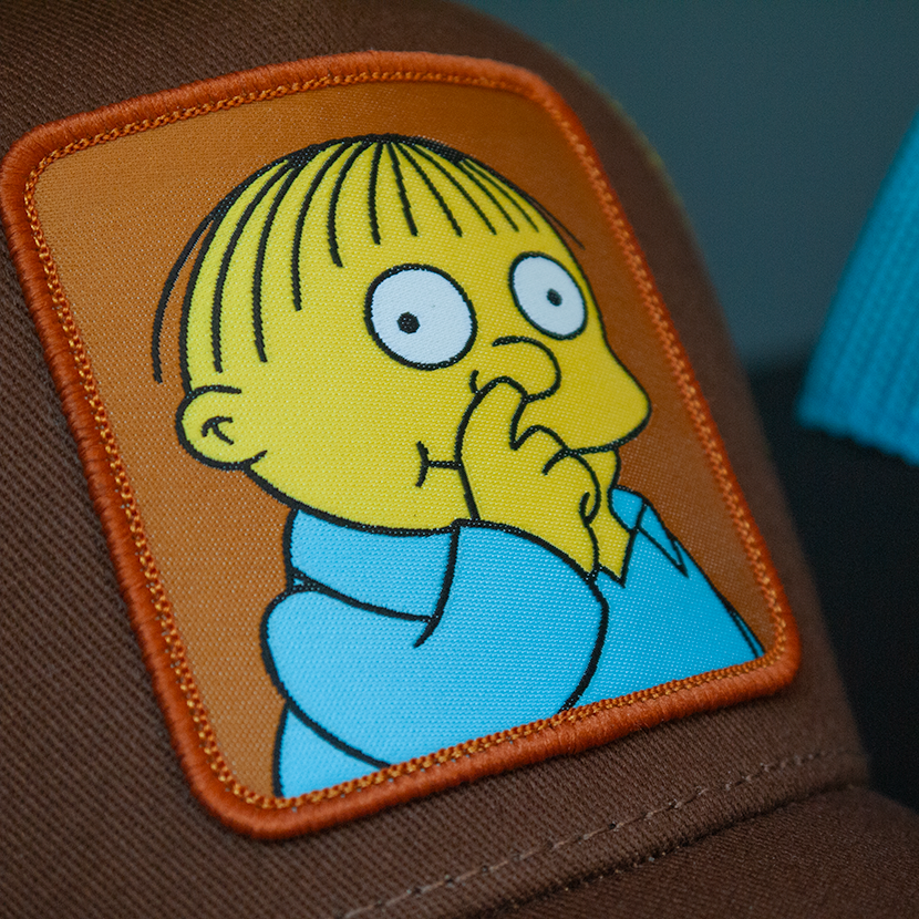 Brown OVERLORD X The Simpsons Ralph Wiggum picking his nose trucker baseball cap hat woven Overlord patch closeup.