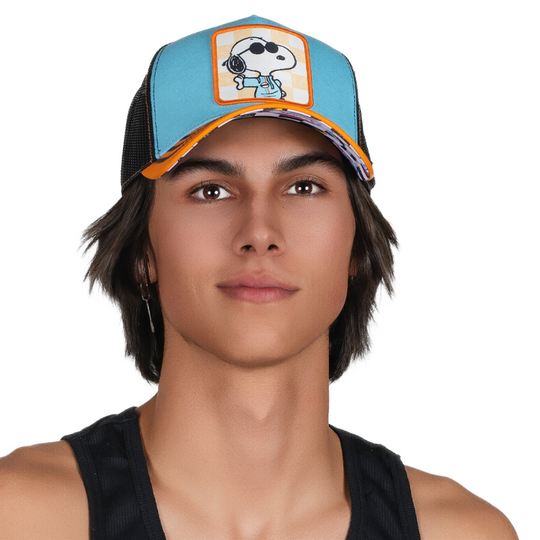 Man wearing blue and orange trucker cap with black mesh featuring a woven patch of Racing Snoopy on orange checkered background attached to crown