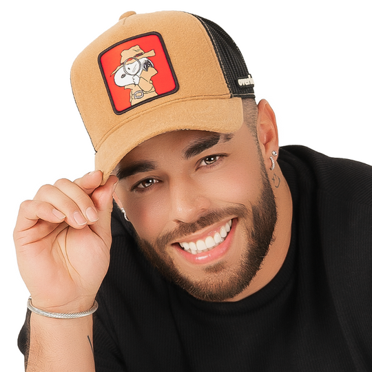 Man wearing brown cashmere wool trucker cap with black mesh featuring a woven patch of Secret Agent Snoopy from Peanuts on the crown.
