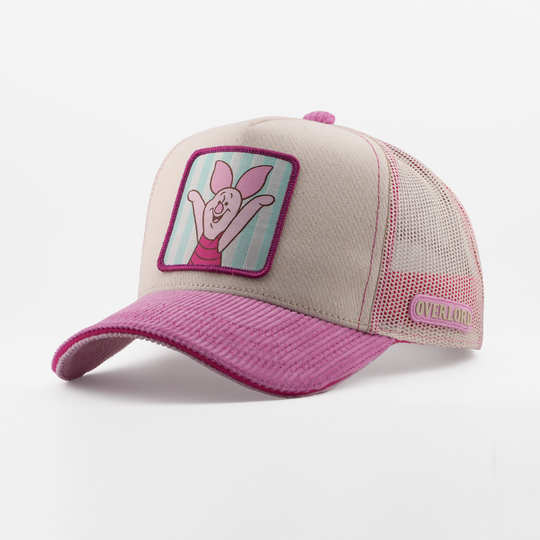 Pink and beige cap with a cartoon character patch on a white background