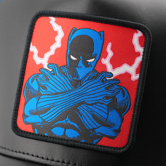 Close-up of a woven Marvel's Black Panther patch with a red backdrop, stitched onto matte black cap fabric.
