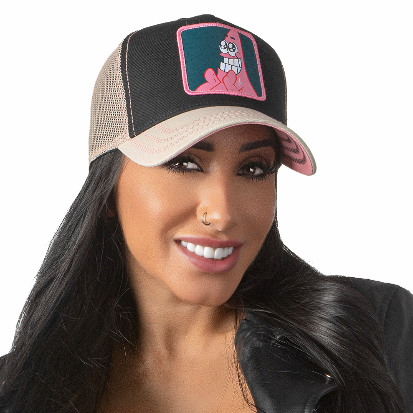 Woman wearing black and tan OVERLORD X SpongeBob Big Smile Patrick trucker baseball cap hat with pink zig zag stitching. PVC Overlord logo.