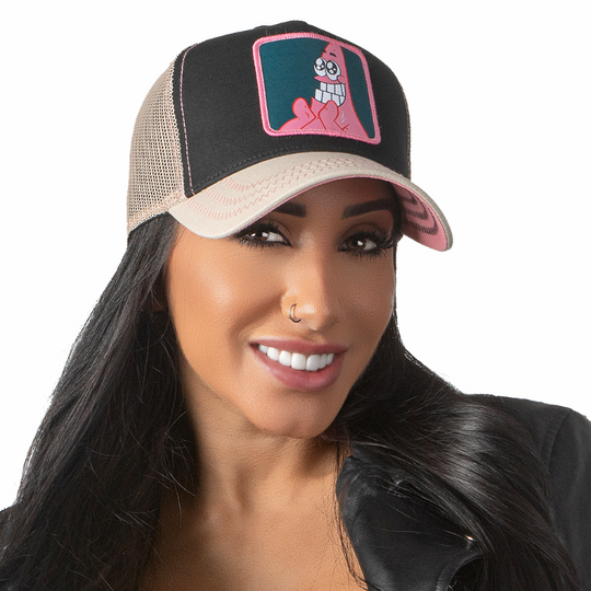 Woman wearing black and tan OVERLORD X SpongeBob Big Smile Patrick trucker baseball cap hat with pink zig zag stitching. PVC Overlord logo.