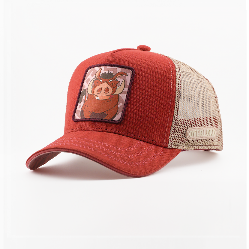 Rust-red corduroy-textured retro trucker cap with a woven Pumbaa from Disney's The Lion King patch on a pink patterned background with a dark purple border, tan mesh back with Overlord logo.