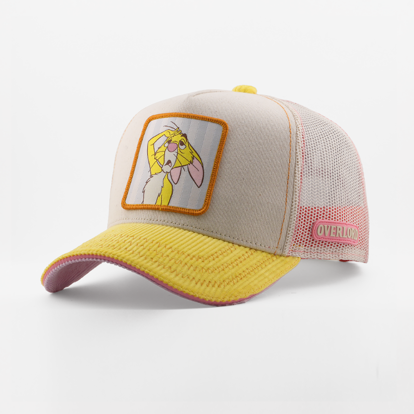 Beige and yellow cap with a cartoon patch on a white background