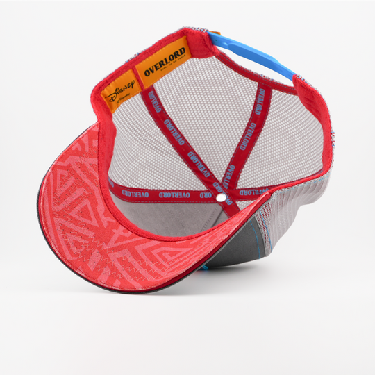 Underside of the Rafiki from Disney's The Lion King retro trucker cap showing a red patterned brim, grey mesh crown, Disney tag, and red Overlord branded taping with blue text.