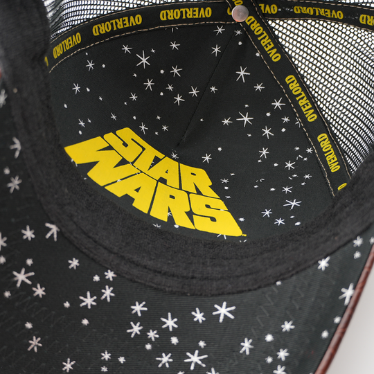 Close-up of the Rancor trucker cap's underside showing a starry black lining with a yellow Star Wars logo and Overlord taping.