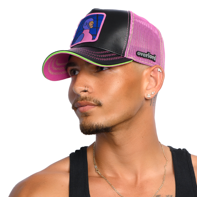Man wearing black faux leather trucker cap with purple mesh featuring a woven patch of Funland Robot villain from Scooby Doo attached to the crown.