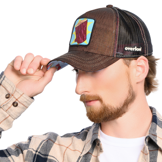 Man wearing brown cork wood trucker cap hat featuring Log from Ren and Stimpy on woven patch attached to crown
