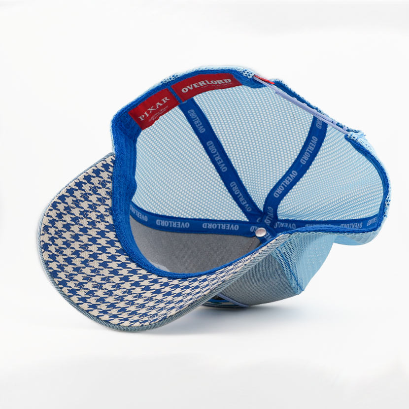 A light blue mesh trucker-style cap shown from the back, featuring a blue and white houndstooth patterned visor, blue elastic back straps, and a red interior label.