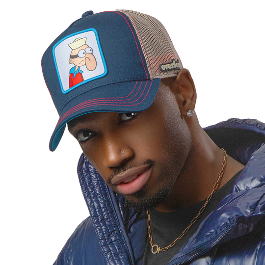 Man wearing navy blue OVERLORD X SpongeBob Barnacle Boy trucker baseball cap hat with red stitching. PVC Overlord logo.