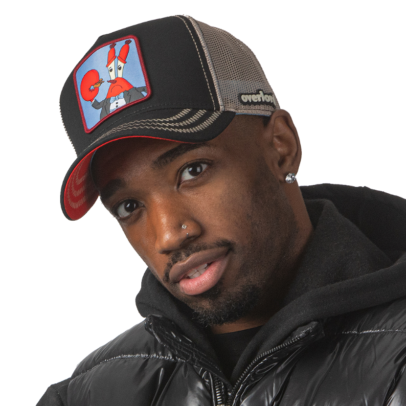Man wearing black OVERLORD X SpongeBob Krabs playing tiny violin trucker baseball cap hat with khaki zig zag stitching. PVC Overlord logo.