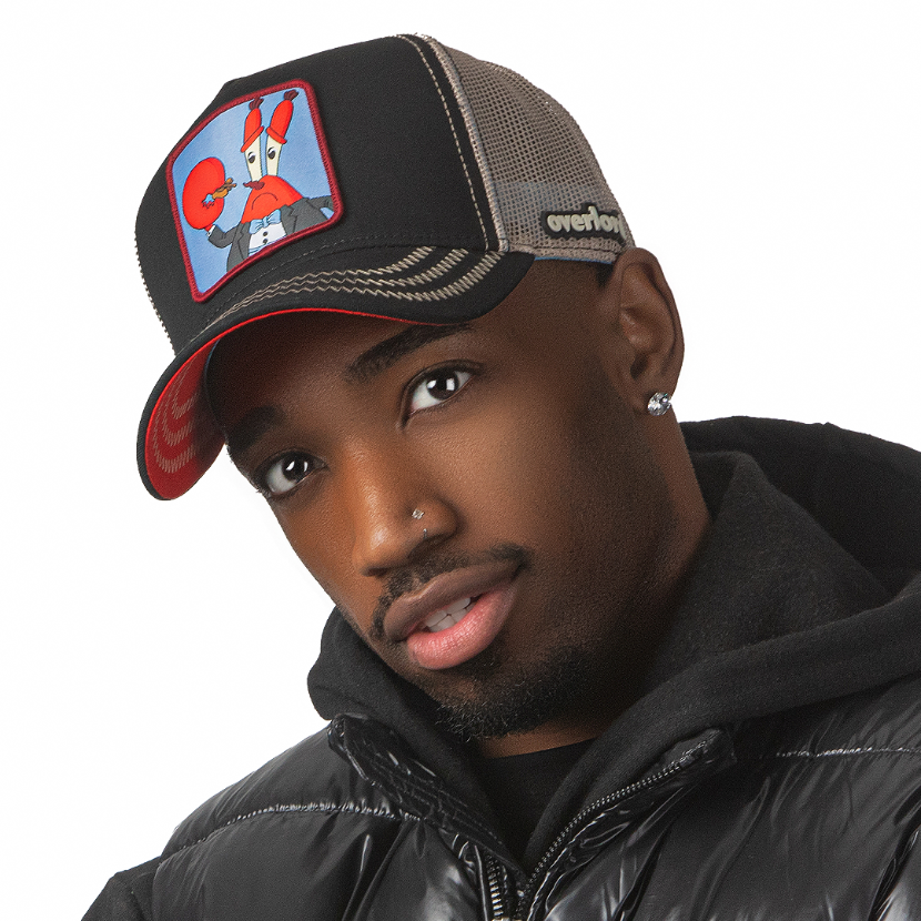 Man wearing black OVERLORD X SpongeBob Krabs playing tiny violin trucker baseball cap hat with khaki zig zag stitching. PVC Overlord logo.
