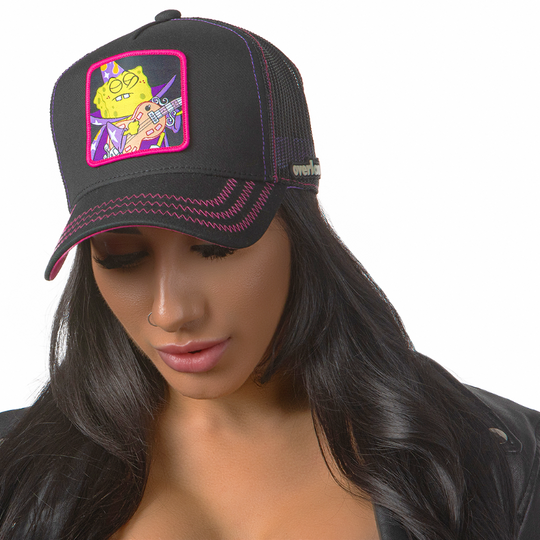 Woman wearing black OVERLORD X SpongeBob Goofy Goober trucker baseball cap hat with hot pink zig zag stitching. PVC Overlord logo.