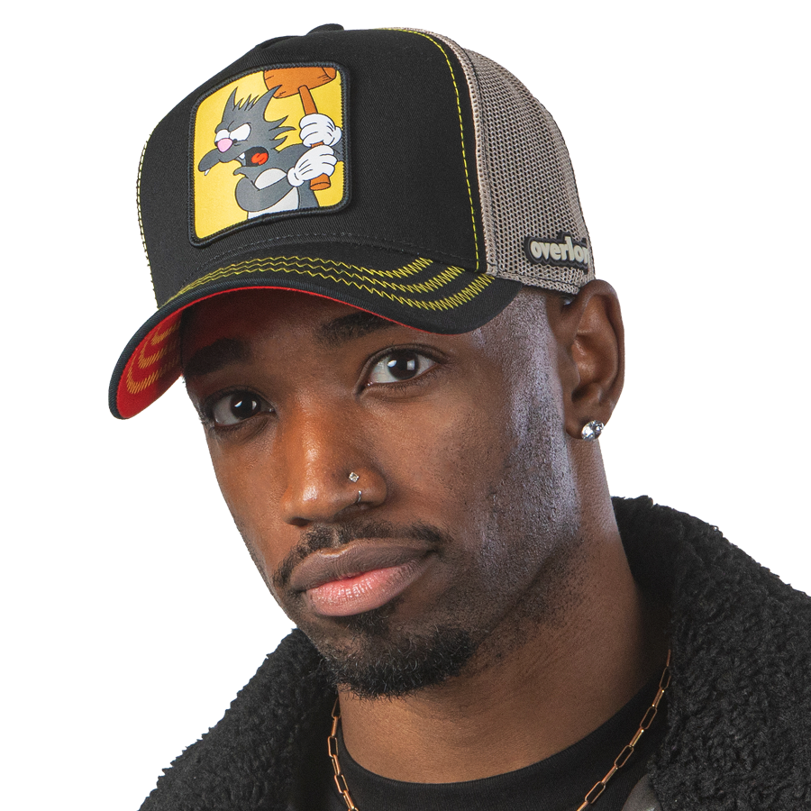 Man wearing black OVERLORD X The Simpsons Scratchy the cat trucker baseball cap hat with yellow zig zag stitching. PVC Overlord logo.