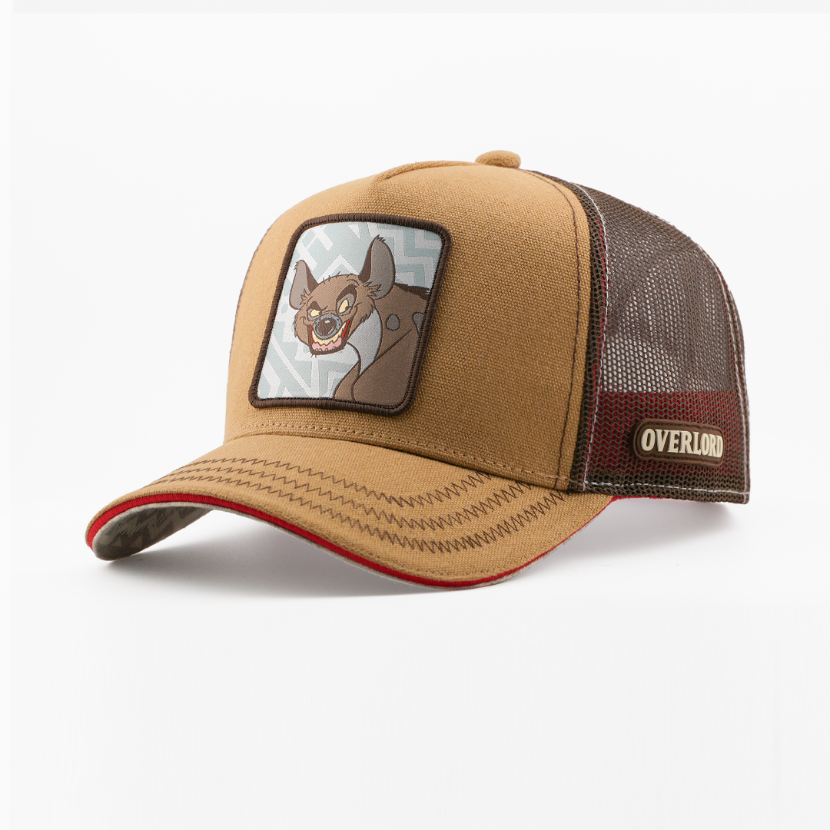 Tan corduroy-textured retro trucker cap with a woven Banzai from Disney's The Lion King patch on a light gray patterned background with a dark brown border, red-trimmed brim, dark brown mesh back with Overlord logo.