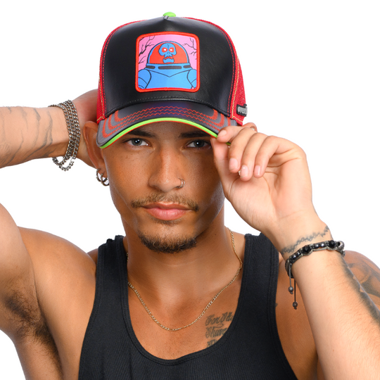 Man wearing black faux leather trucker cap with red mesh featuring a woven patch of Space Kook villain from Scooby Doo attached to the crown.