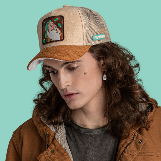 Model wearing the tan suede-textured Sleepy from Disney's Snow White and the Seven Dwarfs retro trucker cap with a brown brim.