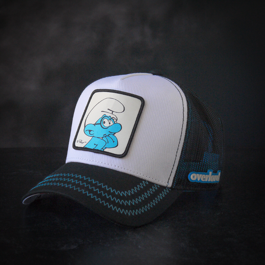 Black and white twill trucker cap with black mesh featuring a woven patch of Brainy Smurf from the Smurfs attached to crown