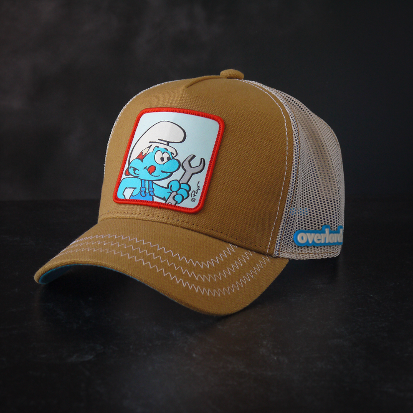 Brown workwear trucker cap with off white mesh featuring a woven patch of Handy Smurf from the Smurfs attached to the crown