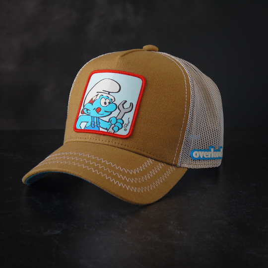 Brown workwear trucker cap with off white mesh featuring a woven patch of Handy Smurf from the Smurfs attached to the crown