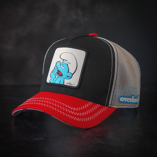 Black and red twill trucker cap with cream mesh featuring a woven patch with Lazy Smurf from the Smurfs attached to crown