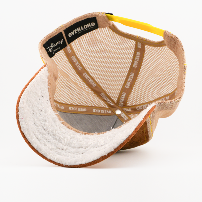 Underside of the Sneezy from Disney's Snow White and the Seven Dwarfs retro trucker cap showing a white fuzzy-textured brim, a Disney tag, tan mesh crown, and tan Overlord branded taping.