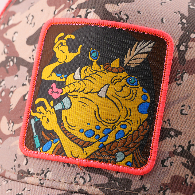 Close-up of a woven Sy Snootles from Star Wars patch with a coral border, stitched onto camo-print trucker cap fabric.