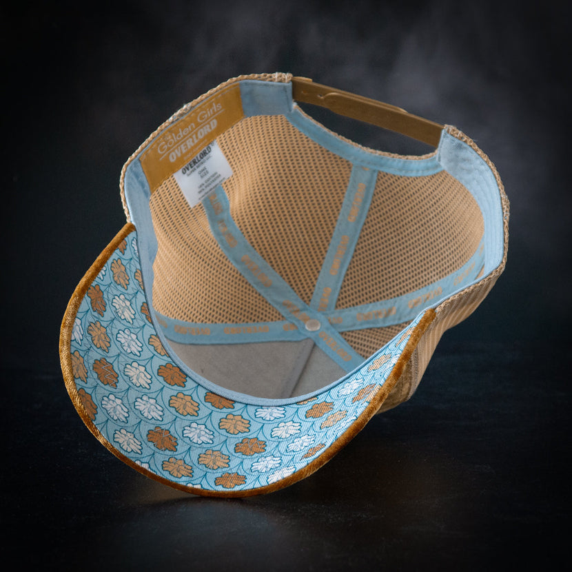 Beige and blue cap with floral pattern on a dark background