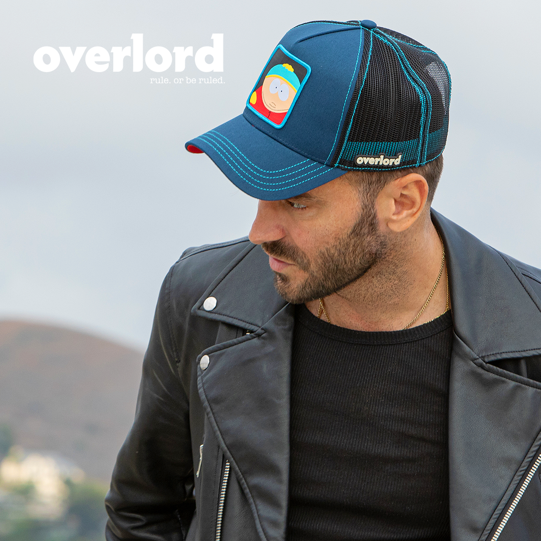 Man wearing navy South Park Eric Cartman trucker baseball cap hat with aqua stitching. PVC Overlord logo.