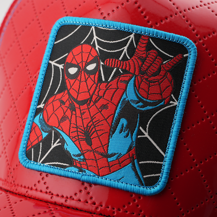 Close-up of a woven Marvel's Spider-Man patch with a blue border, stitched onto glossy red quilted cap fabric.