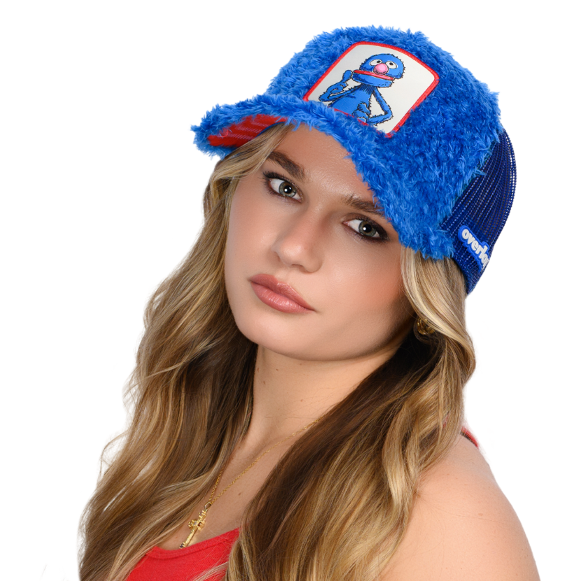 Woman wearing blue faux fur trucker cap hat featuring Grover from Sesame Street on woven patch attached to crown